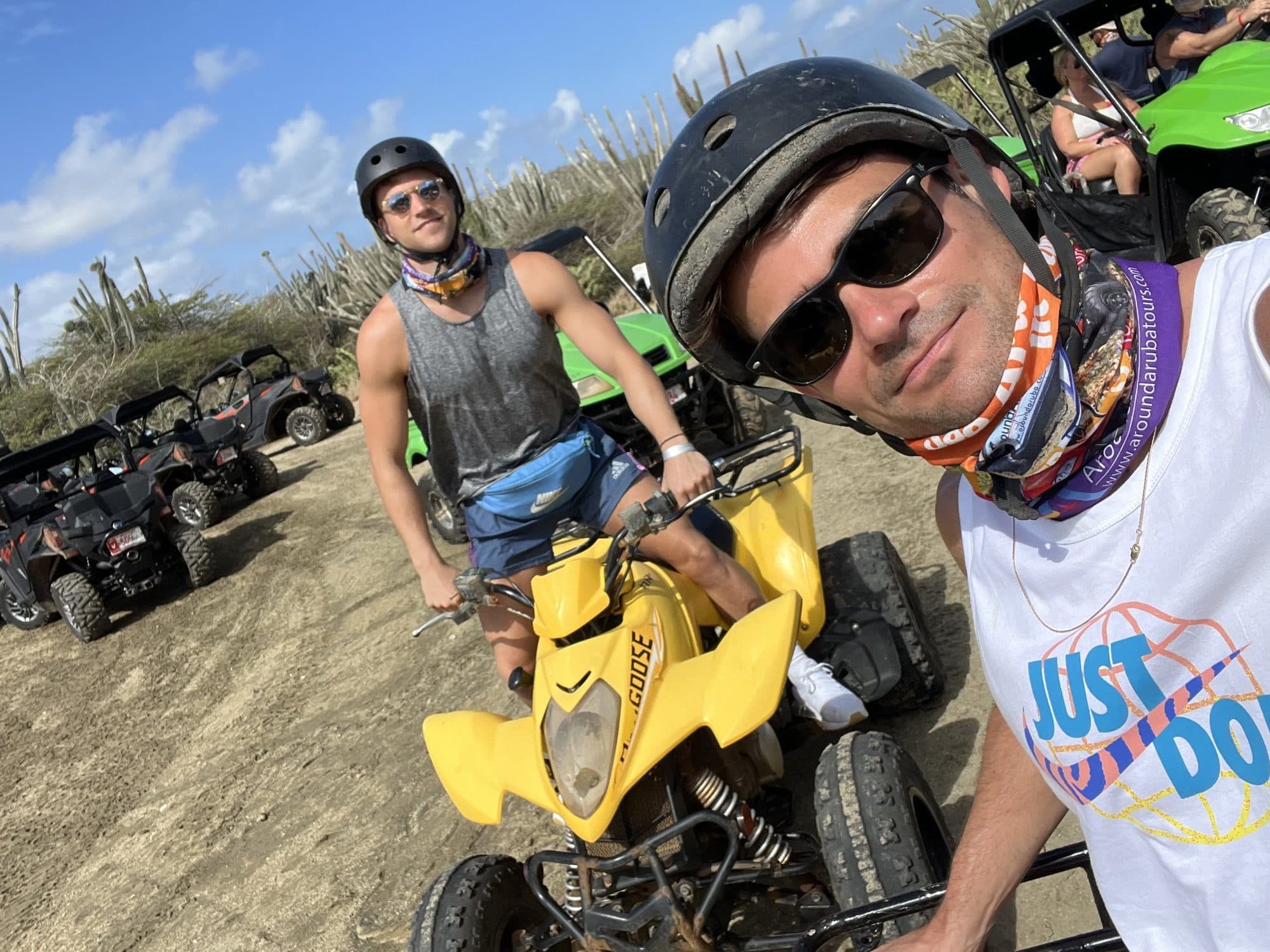 Billy and a friend on ATVs in Aruba's desert landscape