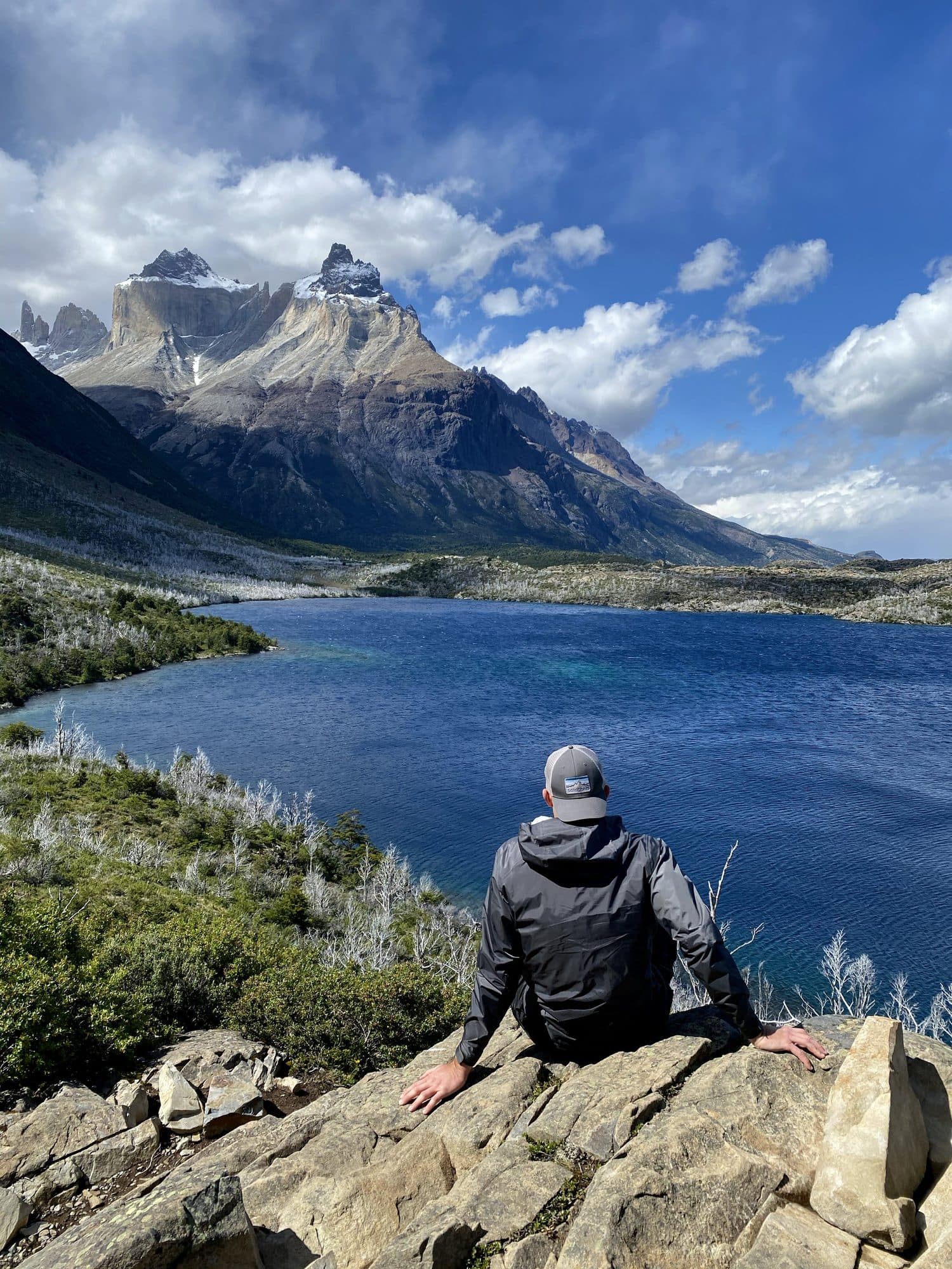 Billy resting on a rock above a deep blue lake