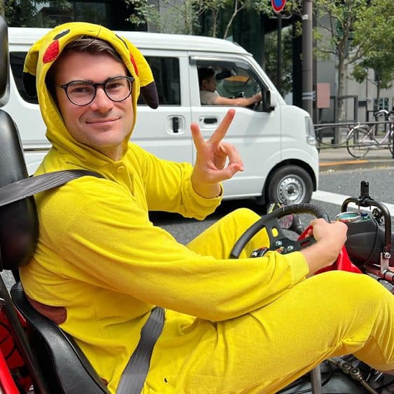 Billy in a Pikachu costume behind the wheel of a go-kart