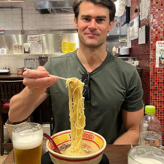 Billy enjoying a bowl of ramen and a beer